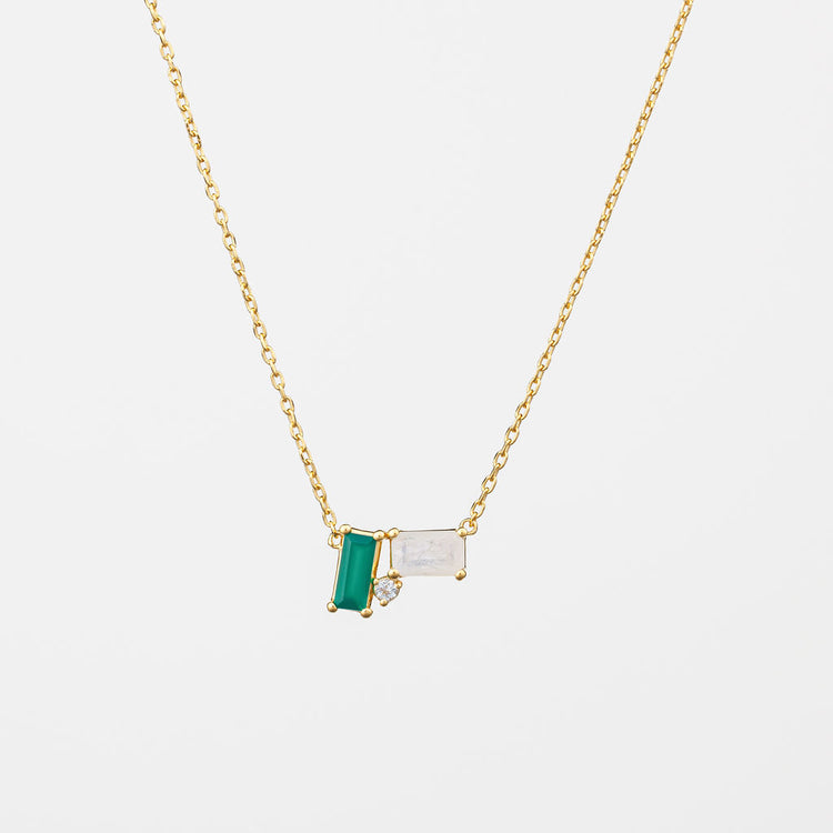 A gold vermeil necklace with a cluster of green onyx and moonstone gemstones, with a white topaz accent stone, on a white background.