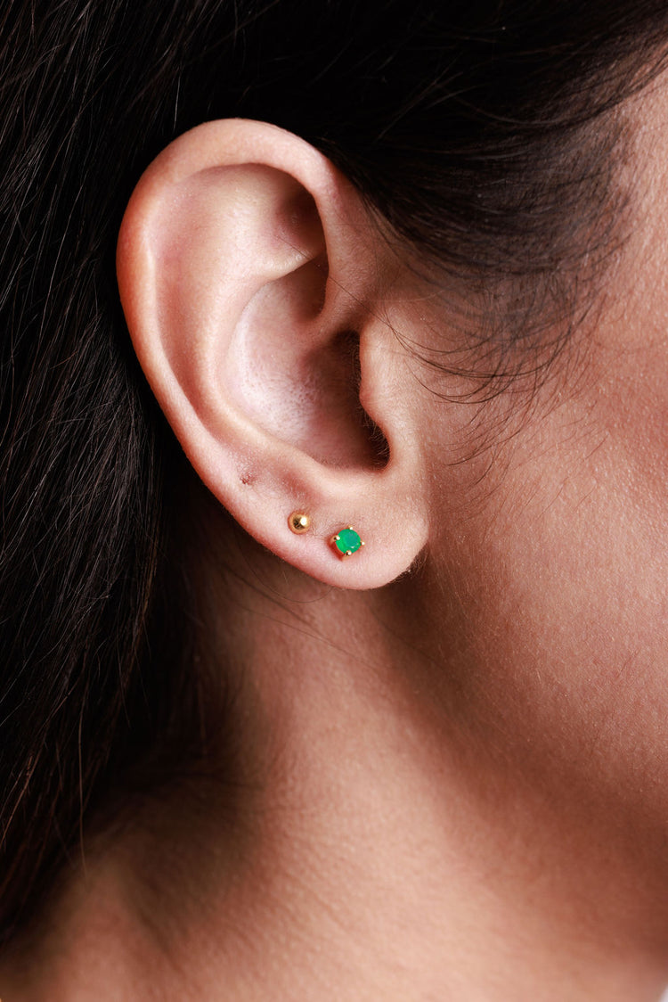 green onyx and gold ball stud earring stacked on a close up ear picture