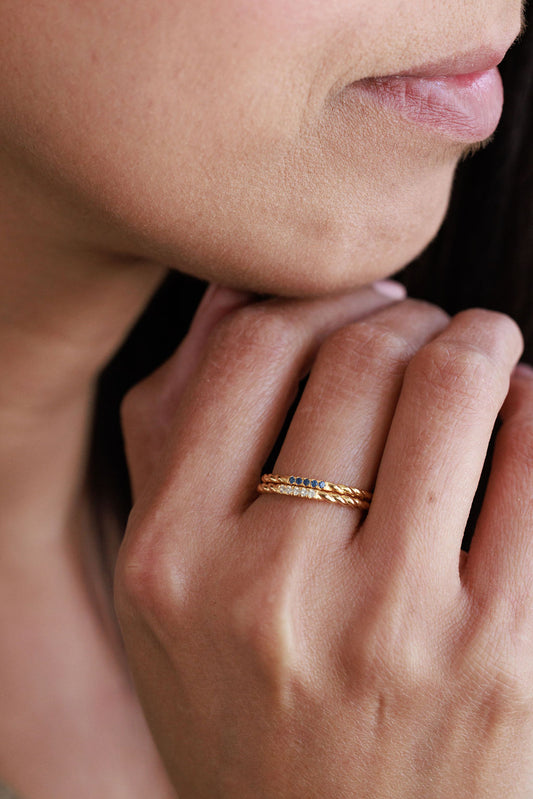 stacked minimalist gold rings with blue sapphire and white topaz