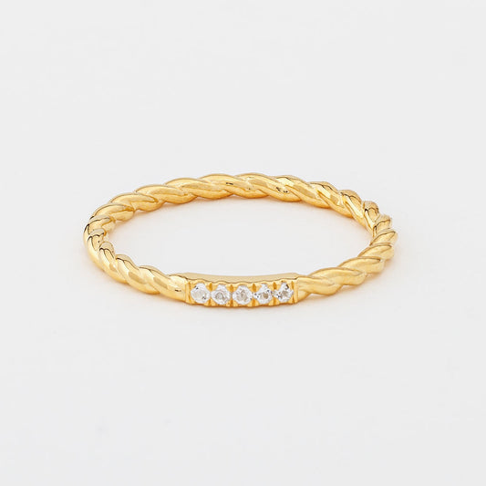 A gold twisted band ring with white topaz gemstones, presented against a white background.