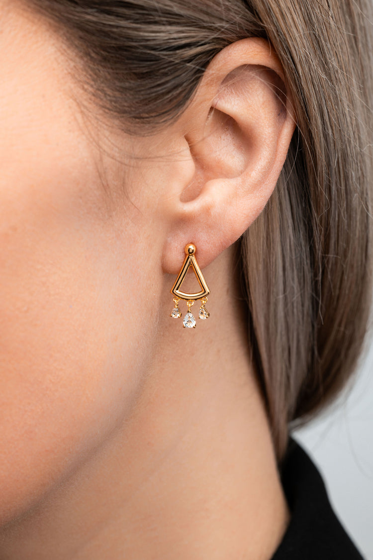 Minimal curved‑triangle gold drop earring with three small white topaz drops hanging from the lower arc.