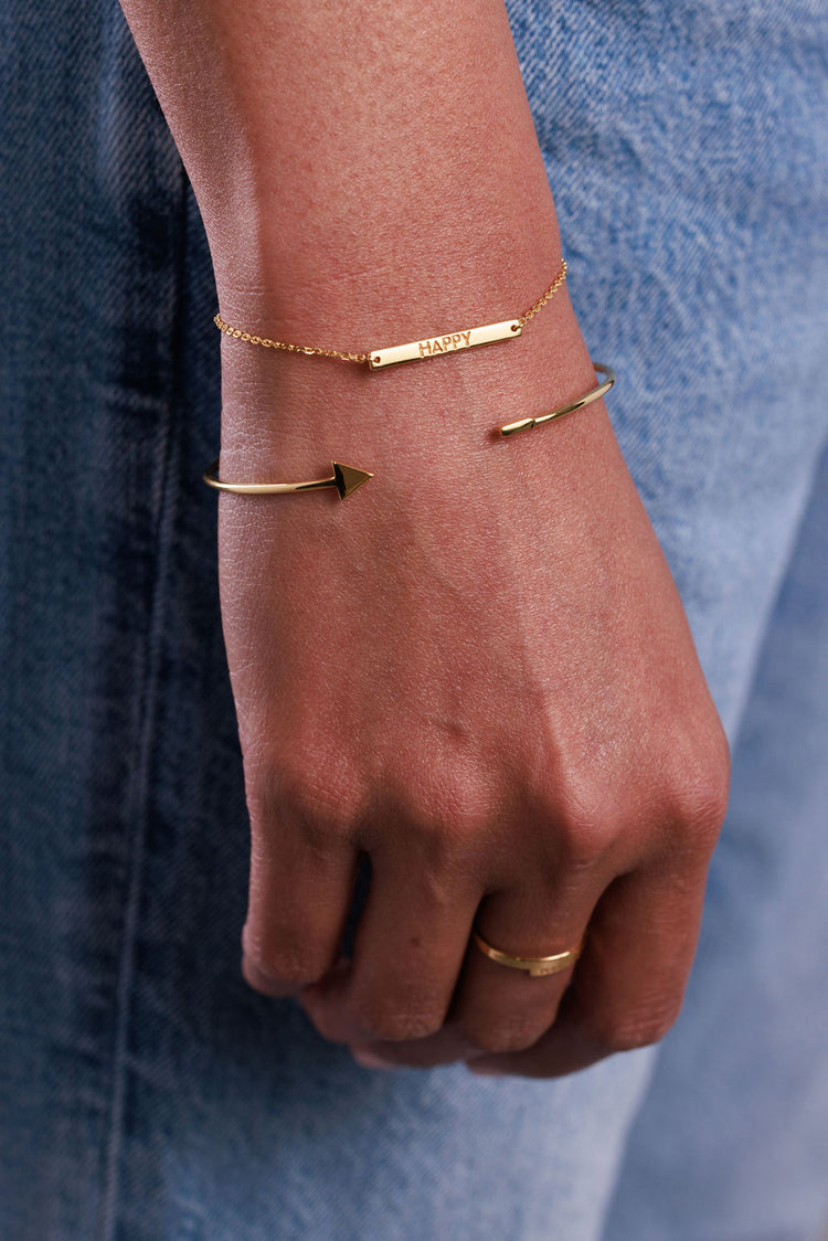Gold bracelet with bar spelling 'happy'
